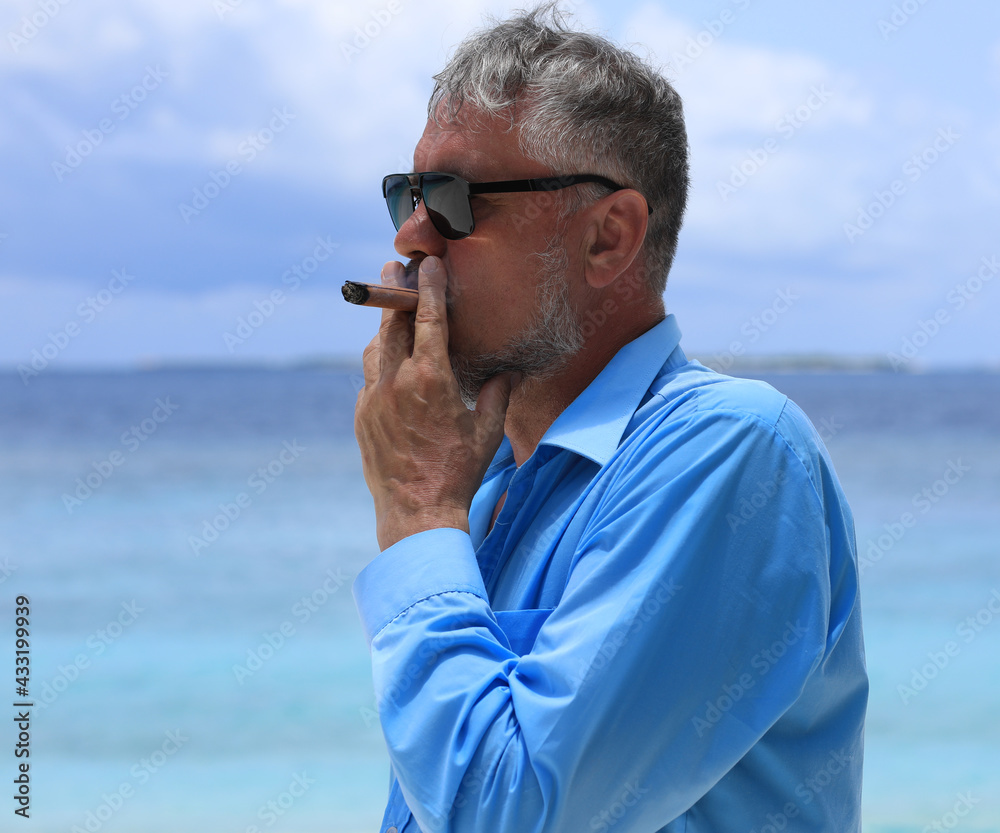 Wall mural man with a cigar on a tropical island