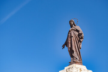 Estatua virgen María inmaculada concepción sobre cielo azul junto a la catedral de Palencia, España - obrazy, fototapety, plakaty