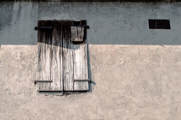 window with old wooden shutters on the concrete wall