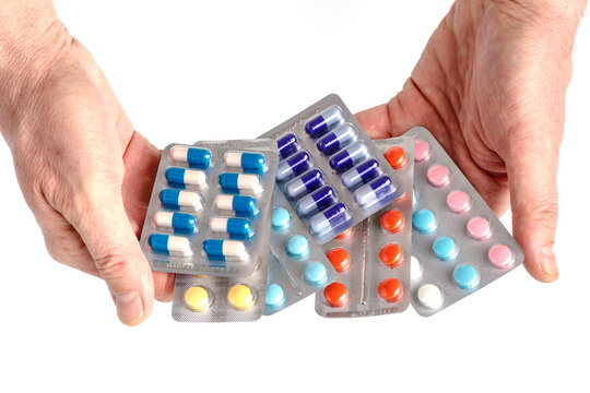 Drug prescription for treatment medication.Close-up of hand holding medication blister packs of tablets and capsules against . Pharmaceutical medicament, cure in container for health. Pharmacy theme