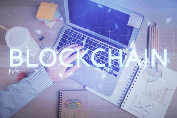 Fototapeta premium Double exposure of man's hands typing over computer keyboard and crypto currency theme hologram drawing. Top view. Blockchain concept.