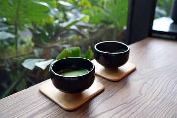 Hot Matcha - A bowl of green tea latte on wooden table and copy space, Traditional Japanese drink.