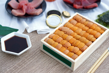 A box of uni sashimi on table served with soy sauce, Fresh sea urchin roe.