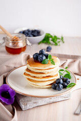 Homemade pancakes with blueberries and powdered sugar on the white table vertical photo