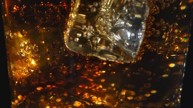 Cold drink with ice cubes slide down shot