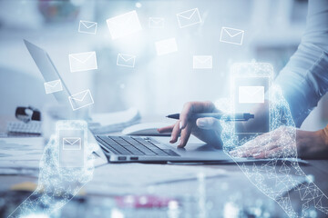 Double exposure of woman hands typing on computer and flying envelop drawing. E-Mail concept.