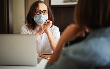 mature woman psychologist is consulting a patient at her office. Back shot of a patient talking about her mental problems during a psychologist's therapist appointment.