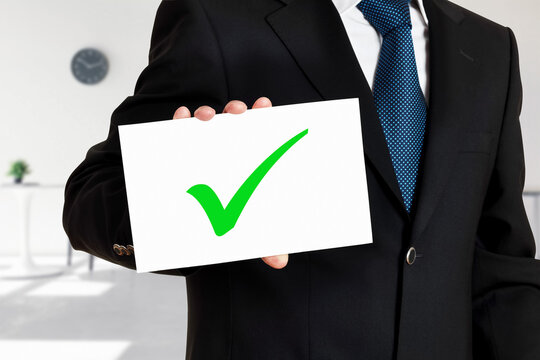 Businessman Holds A Card With The Tick Or Check Mark Icon. Successful Task Completion Or Business Evaluation