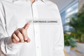 Man press the search bar on a virtual screen with the word continuous learning.