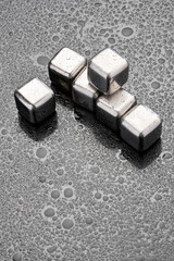 Steel cooling cubes for cocktail drink on glass background