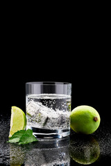Fototapeta na wymiar Glass of Soda or Coctail with steel cooling cubes on dark glass background