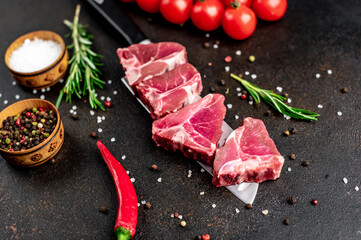 raw T-bone steak on a knife on a stone background