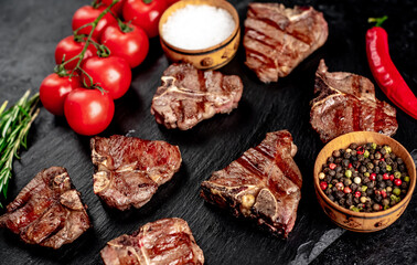 several mini Grilled beef T-bone steaks on stone background