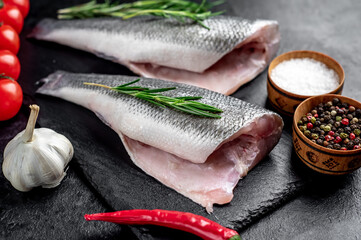 raw fish sea bass with spices on a stone background