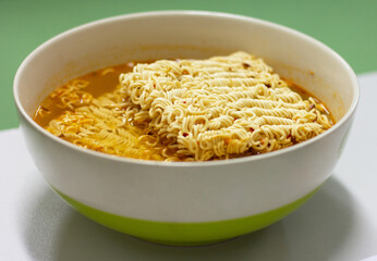 Instant noodles (spicy)  in a bowl, fast food, high sodium.