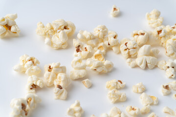 Many pieces of popcorn were scattered on white background.
