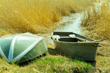 overturned fishing boats in the reeds near the lake