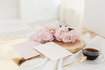 Wedding greeting card concept. Top view mockup on wooden background with peonies flowers. Flat lay style in light colors.