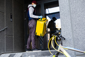 Young delivery man with yellow backpack takeaway concept