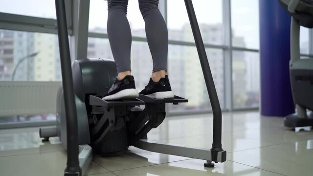 Young woman working out on stepper at gym exercising