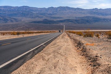 Desert scenic road in Death Valley with mountain backdrop, California, USA. Amazing panorama of desert