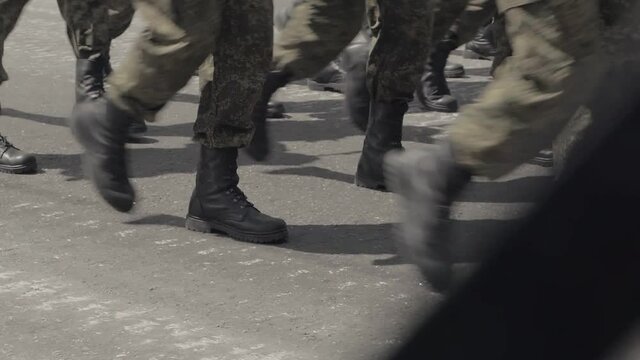 A special forces unit marching through the square. Only the legs are visible in the frame.