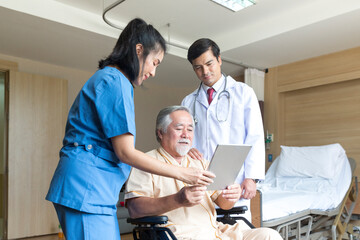 Doctor and nurse using tablet computer to share test results with patient.