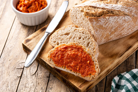 Sliced toast bread with sobrasada on rustic wooden table. Typical Mallorca food in Spain.	
