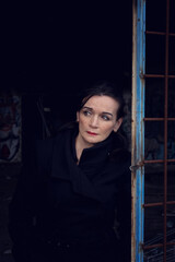 portrait of a woman in her 50s standing at abandoned building