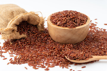 Red rice (brown rice)  in a wooden and sack isolated on a white background, Red rice are scattered on the ground.