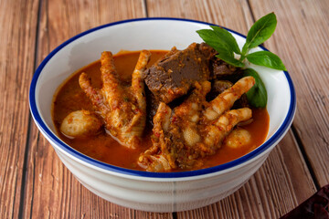 Rice noodles with fish curry sauce, top with meatball, chicken blood cubes, chicken feet, boiled egg and Basil leaves. Thai food, Thai call it 