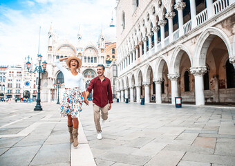 Couple of tourists visiting Venice, Italy - Boyfriend and girlfriend in love running together on...