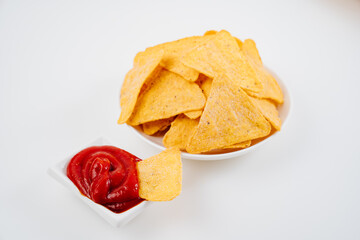 Nachos with tomato sauce on the white table. 