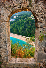 Valtos beach, seen "through" the walls of the Venetian castle of Parga town, Preveza, Epirus, Greece.