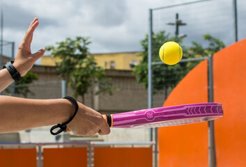 Fototapeta premium Sportsman Playing Paddle Tennis. Hand Holding A Paddle Tennis Racket Hitting The Ball. Sports 