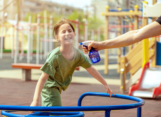 Naklejka premium Dad jumps out with water of the sprayer on his daughter on a hot weather