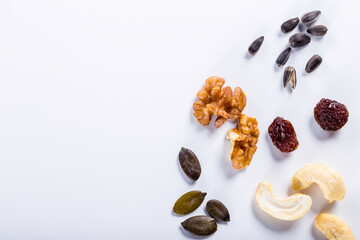 Seeds of sunflower, nuts, fruits and dried fruits on white background with copy space.