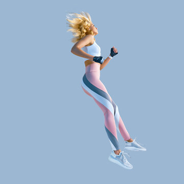Profile picture of energetic inspired caucasian female in sportswear running and jumping, isolated along plain background. Motivation fitness concept photo