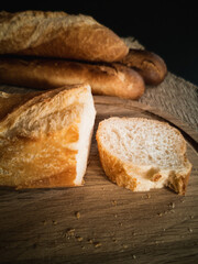 the cut baguette lies on the board and the blurry baguette on the background