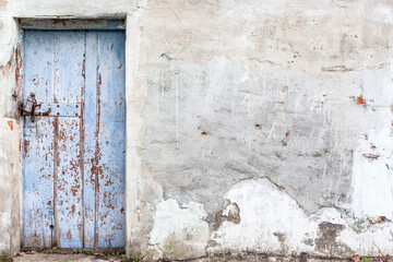 old vintage wooden door against a concrete shattered wall