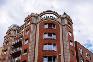 Luxury residential brick buildings in central Madrid. Low angle view of the facade against sky. Rent, market and real estate investment