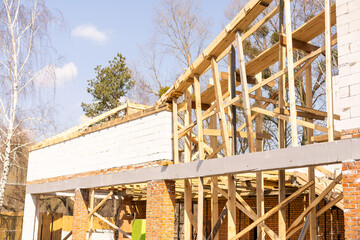 Facade of building made from white blocks with big windows under construction works