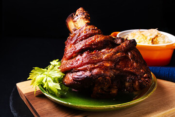 Food concept German pork hock or pork knuckle with sauerkraut cabbage pickle on wooden board with copy space