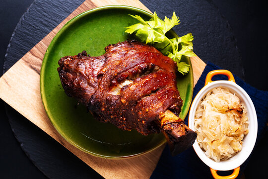 Food concept German pork hock or pork knuckle with sauerkraut cabbage pickle on wooden board with copy space