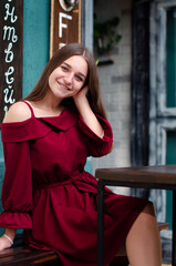 beautiful girl in a red dress on the street in the city