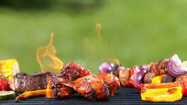 Super slow motion of chicken legs on grill with fire, grass on background. Filmed on high speed cinema camera, 1000 fps