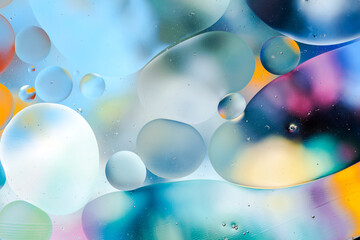 Close-up of the movement of oil droplets on the water surface. Colorful abstract macro background...