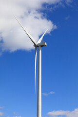 Wind Turbine against Blue Sky and White Clouds 
