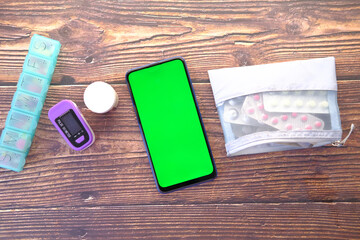 medical pills , pill box and smart phone on table 