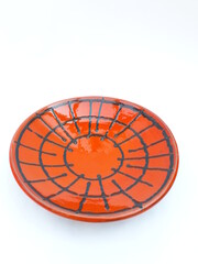 Mid-century modern orange ceramic wall plate with black lines pattern isolated